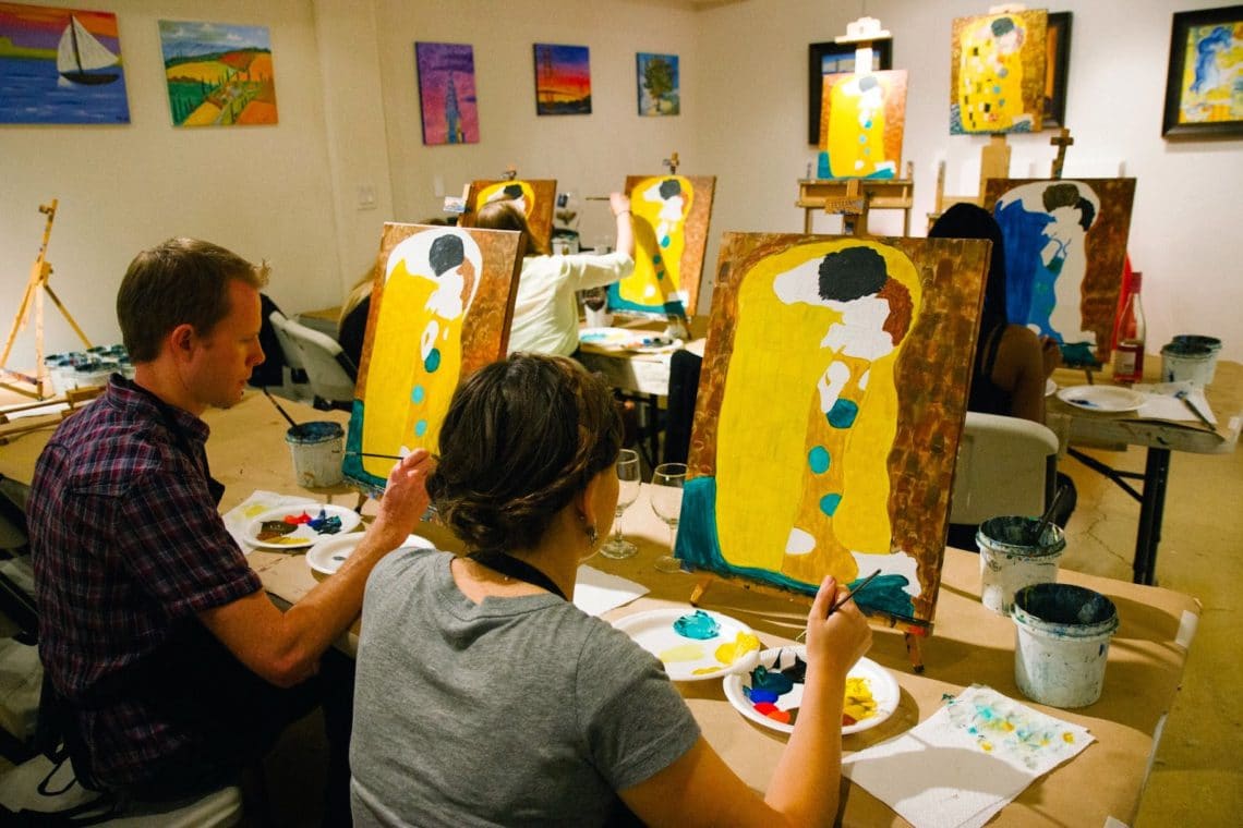 Couple painting The Kiss for a paint night date night.