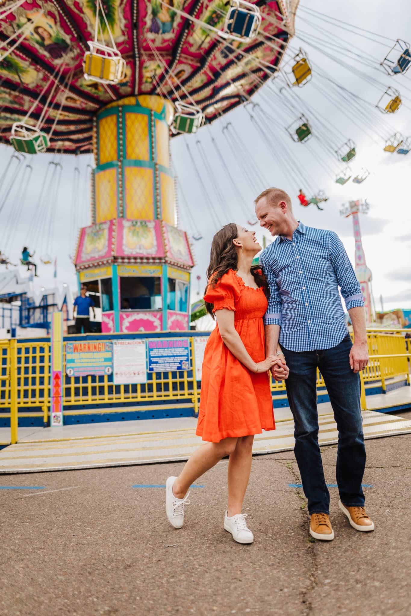 A couple leaning into each other on a date night to the fair sharing the best date ideas for couples to do this year.